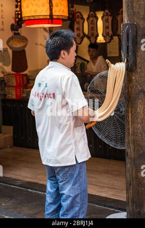 Xian / China - 3. August 2015: Mann, der Nudeln im muslimischen Viertel der Altstadt von Xian, China, zubereitet. Nudeln sind beliebte lokale Spezialität in Xian. Stockfoto