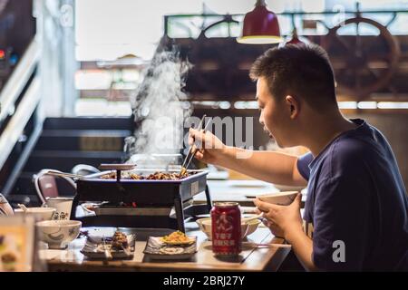 Xian, Provinz Shaanxi / China - 3. August 2015: Mann, der die lokale Xian Küche mit chinesischen Speisen in Xian, China, genießt Stockfoto