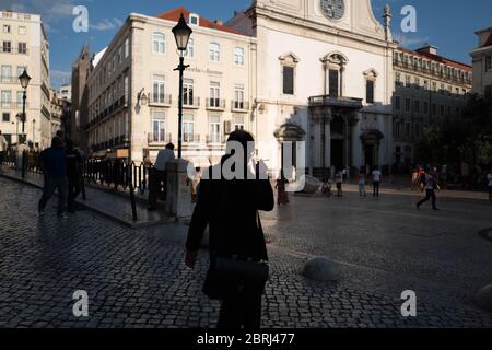 Europa, Portugal, Lissabon. Silhouette eines Mannes, der in einer Lissabonner Straße eine Zigarette raucht. Stockfoto