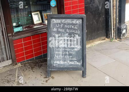 London, Großbritannien - 27. April 2020: Kreide handschriftliche Mitteilung auf Tafel vor John Charles Metzger Shop über reduzierte Öffnungszeiten du Stockfoto