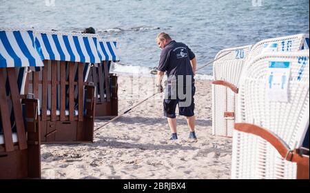 21. Mai 2020, Schleswig-Holstein, Niendorf/Ostsee: Stephan Muuss, Liegenverleih, richtet mit Hilfe eines Messstabs die Liegen am Ostseestrand auf die vorgeschriebene Distanz aus. Foto: Daniel Bockwoldt/dpa Stockfoto