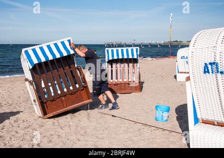 21. Mai 2020, Schleswig-Holstein, Niendorf/Ostsee: Stephan Muuss, Liegenverleih, richtet mit Hilfe eines Messstabs die Liegen am Ostseestrand auf die vorgeschriebene Distanz aus. Foto: Daniel Bockwoldt/dpa Stockfoto