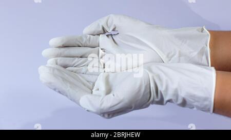 Ärztin, die in beiden Händen medizinische Latexhandschuhe trägt Stockfoto