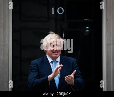 Premierminister Boris Johnson steht in Downing Street, London, um sich dem Applaus anzuschließen, um lokale Helden während des landesweiten Clap for Carers am Donnerstag zu begrüßen, um NHS-Arbeiter und Betreuer zu unterstützen, die gegen die Coronavirus-Pandemie kämpfen. Stockfoto