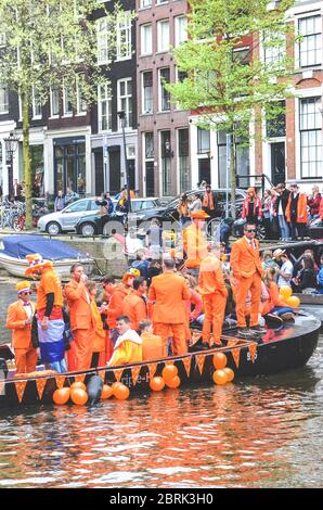 Amsterdam, Niederlande - 27. April 2019: Party-Boot mit Menschen in Nationalorange gekleidet, während der Feier des Königstages, Koningsdag, dem Geburtstag des niederländischen Königs Willem-Alexander. Stockfoto