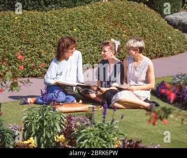 Junge Studentinnen sitzen auf dem Gelände von Guildford Castle, Guildford, Surrey, England, Großbritannien Stockfoto