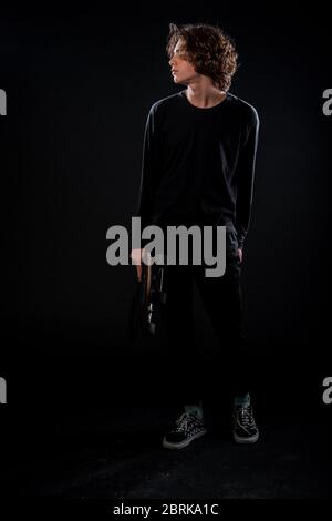 Porträt eines jungen attraktiven Mann in stilvoller Kleidung mit einem Skateboard gekleidet Stockfoto