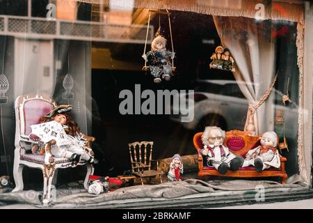 Blick auf ein Puppenhaus Fenster, voll von alten, staubigen Spielzeug. Kinderheiten. Antik Stockfoto