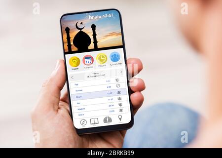 Mann, Der Die Muslim Prayer App Auf Dem Handy Benutzt Stockfoto