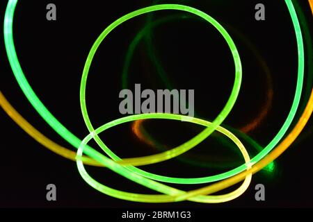 Draht mit grünem und rotem Licht, ein Lichtleiterkabel mit unterschiedlicher Lichtübertragung, Lichtspektrum und Lichteffekten in einem chaotischen Zustand. Stockfoto