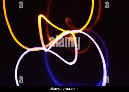 Gelbes und blaues Lichtkabel, ein Lichtleiterkabel mit unterschiedlicher Lichtdurchlässigkeit, unterschiedlichem Lichtspektrum und Lichteffekten, das sich in einem chaotischen Zustand befindet. Stockfoto