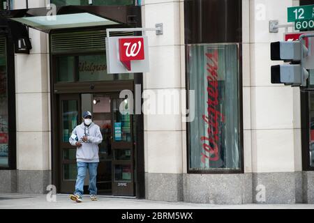 Washington, USA. Mai 2020. Ein maskierter Mann verlässt am 21. Mai 2020 inmitten der Coronavirus-Pandemie eine Walgreens-Ladenfront in Washington, DC. Diese Woche näherte sich die bestätigte US-Todesrate von COVID-19 100,000, während viele Staaten drängen, ihre Volkswirtschaften wieder zu öffnen, obwohl sie die von Gesundheitsexperten empfohlenen Anforderungen für eine sichere Wiedereröffnung nicht erfüllen. (Graeme Sloan/Sipa USA) Credit: SIPA USA/Alamy Live News Stockfoto