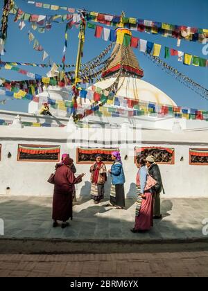 Kathmandu, Bodhnath. Bunte Straßenszenen mit den Gläubigen Gläubigen Gläubigen im weltberühmten Budhnath Buddhist Temple Stupa und Turm, geglaubt, um das 15. Jahrhundert gebaut worden zu sein, ist es der älteste Tempel in nepal. Stockfoto