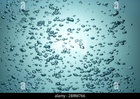 Das Licht durchbricht das blaue Wasser mit Blasen. Stockfoto