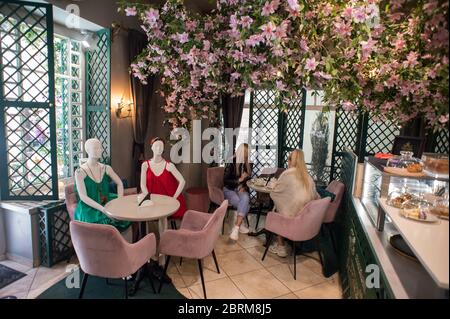 Vilnius, Litauen. Mai 2020. Am 21. Mai 2020 speisen die Kunden in einem Café in der Altstadt von Vilnius, Litauen, neben Mannequins gekleideten Kreationen lokaler Designer. Cafés und Restaurants wurden am Donnerstag zu einer Plattform, um Kollektionen lokaler Designer zu präsentieren, die von der Sperrung der COVID-19 betroffen waren, da das Land Bars, Cafés und Restaurants unter strengen Sicherheitsregeln betrieben hat. Kredit: Alfredas Pliadis/Xinhua/Alamy Live News Stockfoto