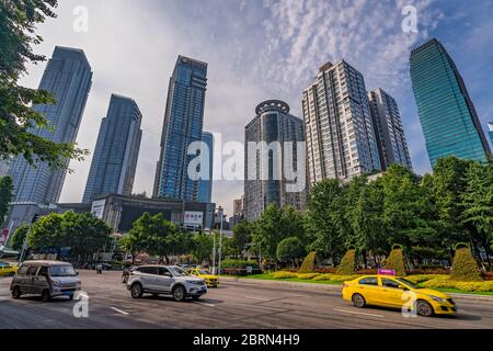 Chongqing, China - Juli 2019: Taxis und Autos fahren auf belebten Straßen der Stadt Chongqing unter den modernen Handels- und Geschäftsgebäuden im Jief Stockfoto