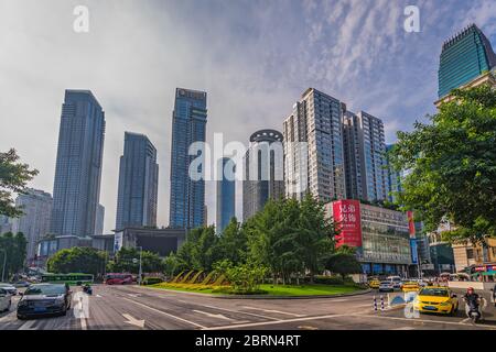 Chongqing, China - Juli 2019: Taxis und Autos fahren auf belebten Straßen der Stadt Chongqing unter den modernen Handels- und Geschäftsgebäuden im Jief Stockfoto