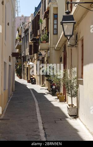 Typisch griechisch schmale sonnendurchflutete Gasse mit Pflanzen und Moterbikes, Rethymno, Kreta, Griechenland Stockfoto