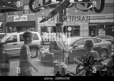 Manhattan, Kansas, USA. Mai 2020. Die Familie Weddle wartet am Mittwoch vor dem Campus Barbershop auf den Haarschnitt. Der Campus Barbershop in Aggieville, Kansas ältestem Einkaufsviertel, ist seit März 17 geschlossen und hat zwei Tage geöffnet. Mai 18 war der erste Tag der Phase 1.5 des Plans, Kansas Wirtschaft wieder zu öffnen. Kredit: Luke Townsend/ZUMA Wire/Alamy Live News Stockfoto