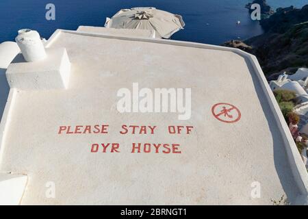 Oia, Santorini, Griechenland - 22. Juli 2014: Schild auf einem Dach eines griechischen Hauses mit der Aufschrift "Bitte bleiben Sie von unserem Haus weg", um zu vermeiden, dass Touristen auf das Haus treten Stockfoto