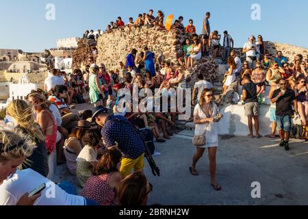 Oia, Santorini, Griechenland - 22. Juli 2014: Massen von Touristen warten auf Sonnenuntergang am Aussichtspunkt auf der Burg Stockfoto