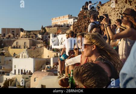 Oia, Santorini, Griechenland - 22. Juli 2014: Massen von Touristen warten auf Sonnenuntergang am Aussichtspunkt auf der Burg und dem Dorf Stockfoto