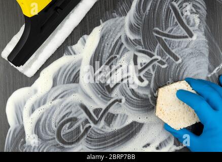 Beschriftung sauber auf schwarzen schmutzigen Fliesen. Reinigung und Desinfektion von Werkzeugen und Geräten. Draufsicht. Stockfoto