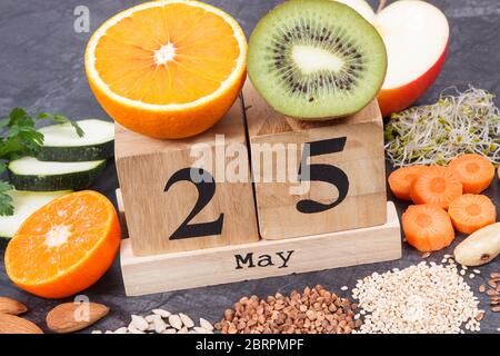 Würfelkalender mit Datum des Welt Schilddrüse Day und beste Lebensmittel mit natürlichen Mineralien und Vitaminen für eine gesunde Schilddrüse Stockfoto