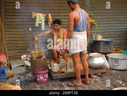 Ein Straßenhändler bereitet in seinem Stall Tee zu. Stockfoto