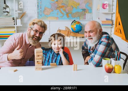 Vater und Sohn spielen Jenga mit Enkelkind. Glückliche Männer lieben Familie. Freundschaft der männlichen Generationen. Männerfamilie Stockfoto