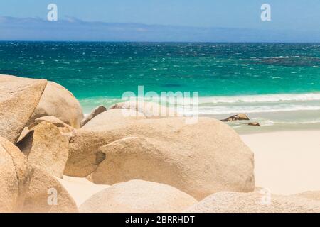 Camps Bay Beach türkisfarbenes Wasser weißer Sand und Felsen in Kapstadt, Südafrika. Stockfoto