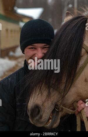 Pferd und Jockey. Junger Jockey und seine Pferde. Tierliebe. Liebe zum Pferd. Wunderschönes Pferd. Baschkir Pferd, Baschkir Curlies in Ufa, Baschkortostan, Russland. Stockfoto