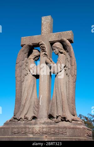 Sydney Australien, Engel mit Kreuz Statue auf dem denkmalgeschützten Waverley Cemetery A mit einer bedeutenden Anzahl von viktorianischen und Edwardia Stockfoto