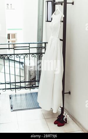 Wunderschöne weiße Hochzeitskleid auf einer Feuerleiter auf dem Balkon. Braut Accessoires in einem Hochzeitstag Stockfoto