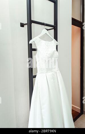 Wunderschöne weiße Hochzeitskleid auf einer Feuerleiter auf dem Balkon. Braut Accessoires in einem Hochzeitstag Stockfoto