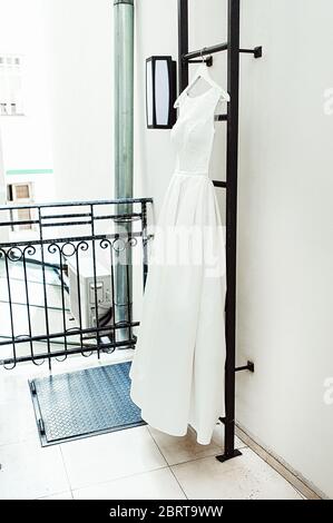Wunderschöne weiße Hochzeitskleid auf einer Feuerleiter auf dem Balkon. Braut Accessoires in einem Hochzeitstag Stockfoto