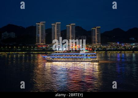 Chongqing, China - August 2019 : Luxus-Passagier-Touristenschiff Kreuzfahrt auf dem Yangtze und Jialing Fluss in der Nacht mit beleuchteten Wolkenkratzern in t Stockfoto