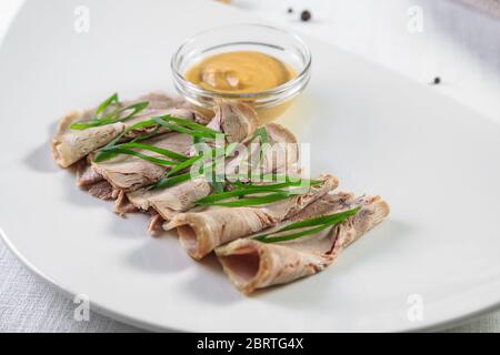 Kalt geräucherter Fleischteller mit Schweinekoteletts, Prosciutto, Salami und Brotstäbchen auf weißem Holzhintergrund. Von oben Stockfoto