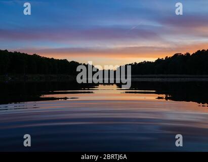 Kersdorf, Deutschland. Mai 2020. Der Abendhimmel leuchtet bei Sonnenuntergang bunt und spiegelt sich im Wasser des Kersdorfer See, einem Naturschutzgebiet in der oder-Spree. Quelle: Patrick Pleul/dpa-Zentralbild/ZB/dpa/Alamy Live News Stockfoto