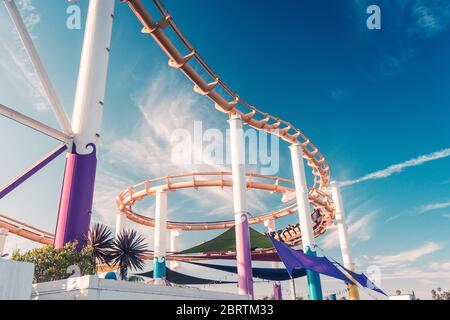 Achterbahn im berühmten Pacific Park auf einem Pier von Santa Monica im goldenen Sonnenuntergang Licht Stockfoto