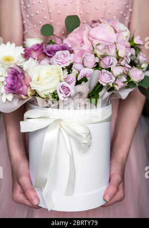 Blumen Set. Schöner Luxus-Blumenstrauß in einer weißen runden Box in weiblichen Händen. Stockfoto