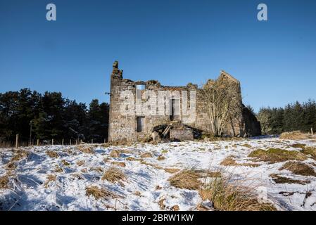 Abgelegenes verödltes Ferienhaus in schneebedecktem Feld in Lanarkshire, Schottland Stockfoto