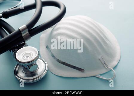 Operationsmaske mit Stethoskop konzeptuell der Covid-19 und Coronavirus-Pandemie in einem hohen Winkel Ansicht über einem weißen Hintergrund Stockfoto