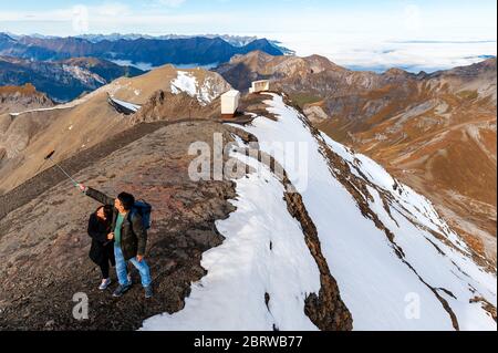 Ein paar Touristen machen Selfies am Aussichtspunkt Schilthorn Ridge auf dem Gipfel des Schilthorn in den Schweizer Alpen Stockfoto