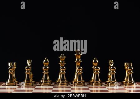 Goldene Schachfiguren stehen auf dem Schachbrett Stockfoto