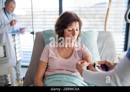 Arzt und Krankenschwester untersuchen eine ältere Frau Patientin im Krankenhaus. Stockfoto
