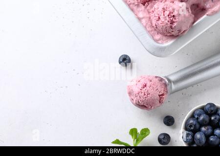 Heidelbeere und Banane hausgemachtes Eis oder Sorbet Ball in Schaufel auf weißem Hintergrund. Nahaufnahme. Platz für Text. Stockfoto