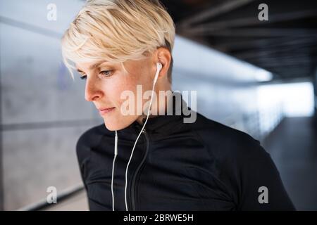 Ein Porträt der jungen Sportlerin, die im Freien Sport macht und sich ausruht. Stockfoto