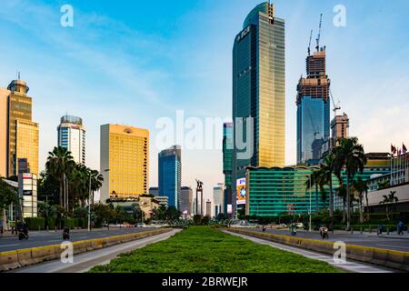 Die Skyline von Jakarta rund um den HI-Kreisverkehr (Bundaran HI), von der MH Thamrin Street aus gesehen, bei Sonnenuntergang. Diese Region ist das zentrale Geschäftsviertel von Jakarta. Stockfoto