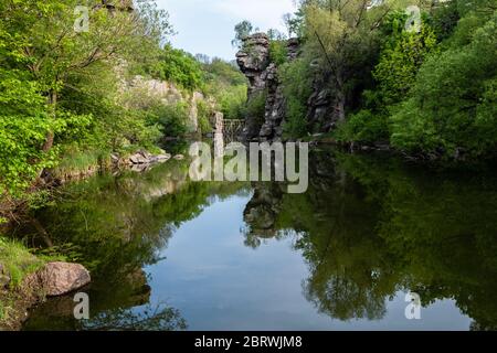 Ruhiger Fluss fließt in Canyon mit überhängenden Klippen an zwei Ufern, Buky Canyon, in der Nähe von Dorf Buki, Tscherkassy Region, Ukraine Stockfoto